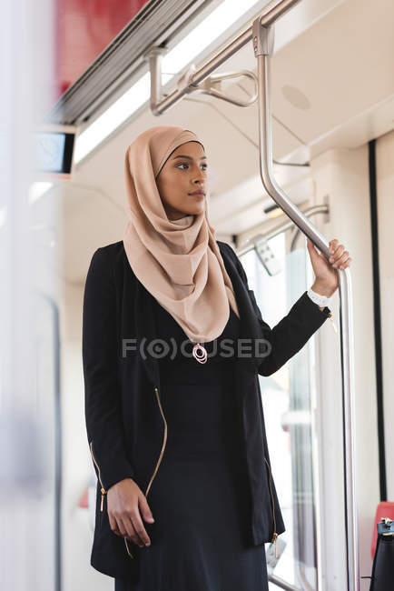 Hidschab-Frau schaut während Zugfahrt durch Fenster — Stockfoto