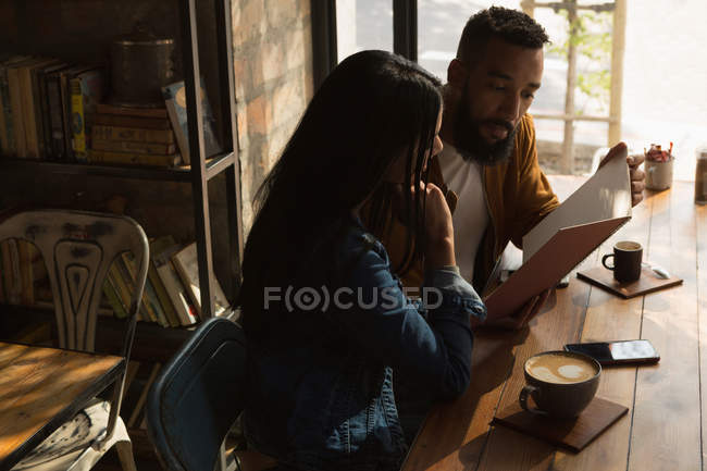 Романтическая пара смотрит меню в кафе — стоковое фото