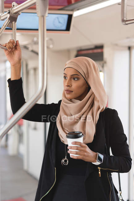 Hidschab-Frau schaut während Zugfahrt durch Fenster — Stockfoto