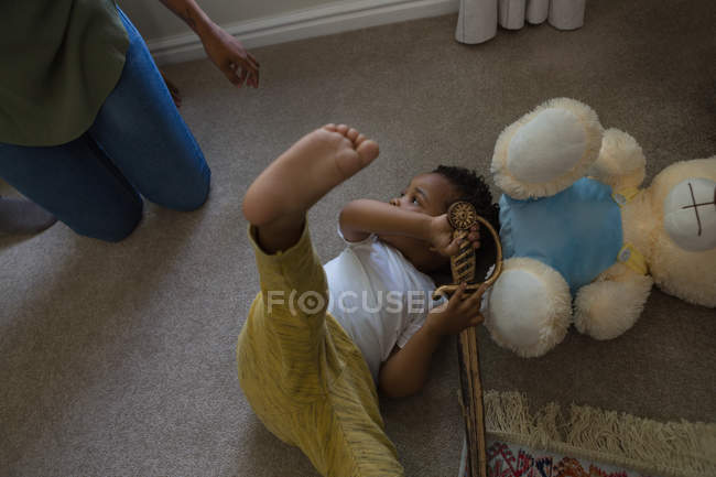 Маленький хлопчик лежить на підлозі у вітальні вдома — стокове фото