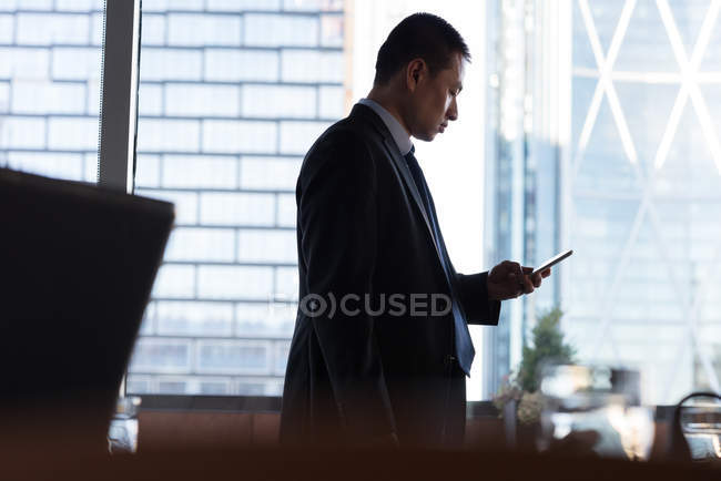 Empresário usando telefone celular na sala de conferências do hotel — Fotografia de Stock