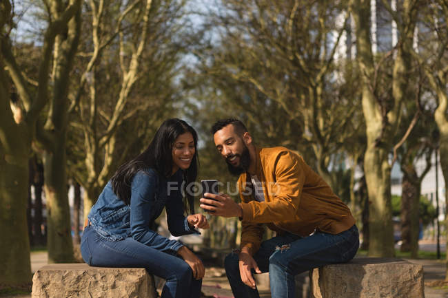 Романтическая пара с использованием мобильного телефона в городе — стоковое фото