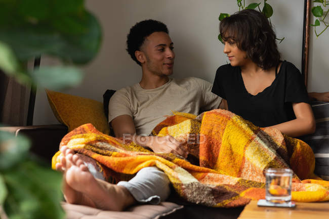 Couple interacting with each other on sofa in living room at home — Stock Photo