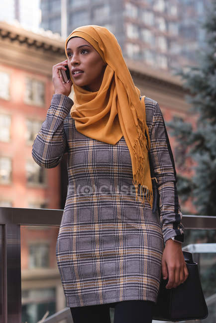 Женщина-хиджаб разговаривает по мобильному телефону в городе — стоковое фото