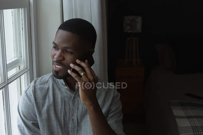 Uomo che parla al cellulare in un soggiorno a casa — Foto stock