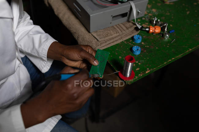 Close up of worker using soldering iron in glass factory — Stock Photo