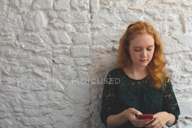 Donna rossa che utilizza il telefono cellulare in caffè — Foto stock