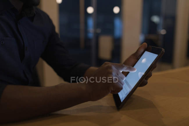 Середина бізнесмена, використовуючи цифровий планшет за столом в офісі — стокове фото