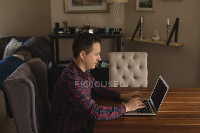 Людина використовує ноутбук у вітальні вдома — стокове фото