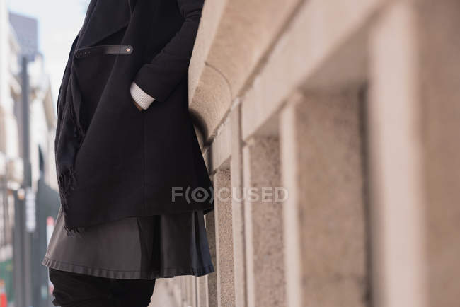 Seção média de mão mulher no bolso em pé na cidade — Fotografia de Stock