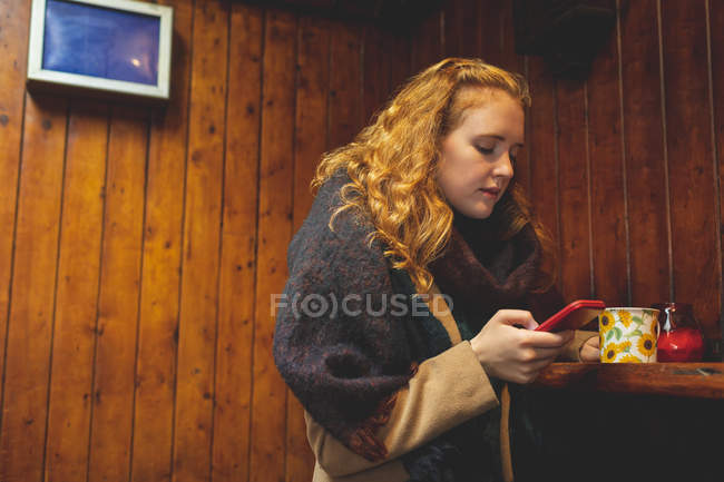 Redhead woman using mobile phone in cafe — Stock Photo