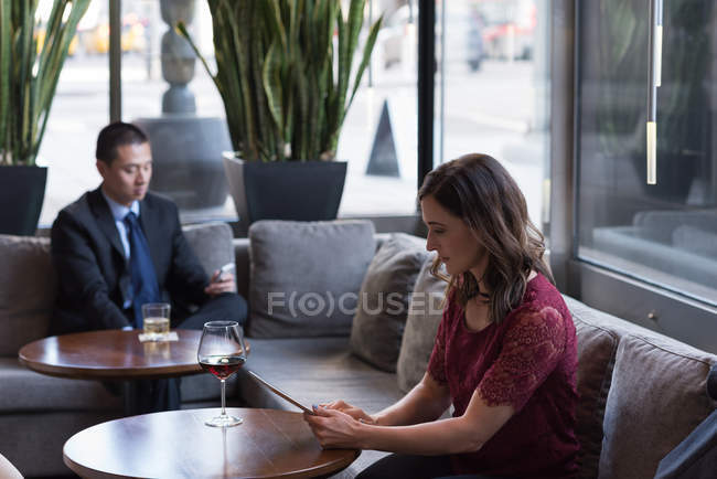 Businesswoman using digital tablet on sofa in hotel — Stock Photo