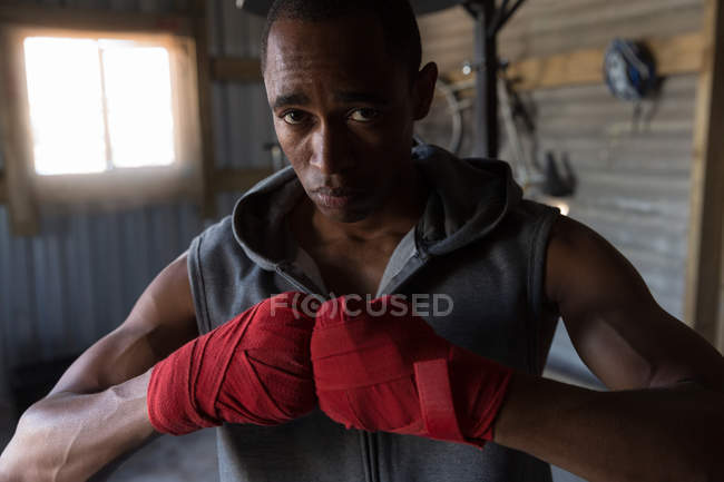 Portrait of male boxer standing with fests in boxing club — Stock Photo