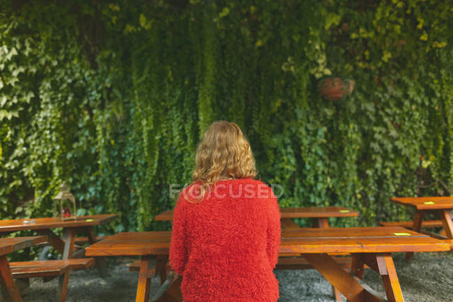 Vue arrière de la rousse femme se détendre dans un café extérieur — Photo de stock