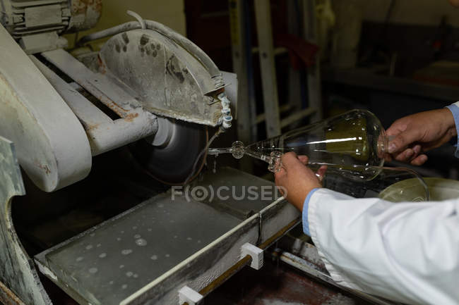 Primer plano del trabajador que examina el producto de vidrio en la fábrica de vidrio - foto de stock
