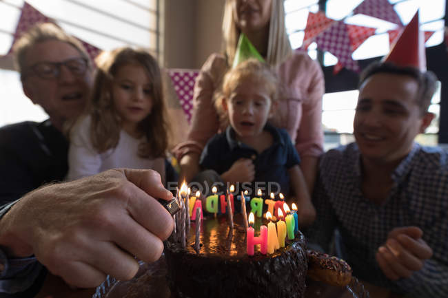 Familia multigeneracional celebrando cumpleaños en la sala de estar en casa - foto de stock