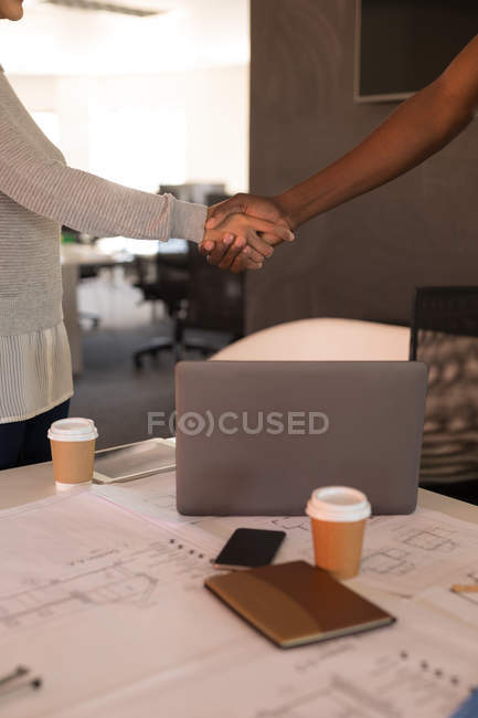 Business executive shaking hands in office — Stock Photo