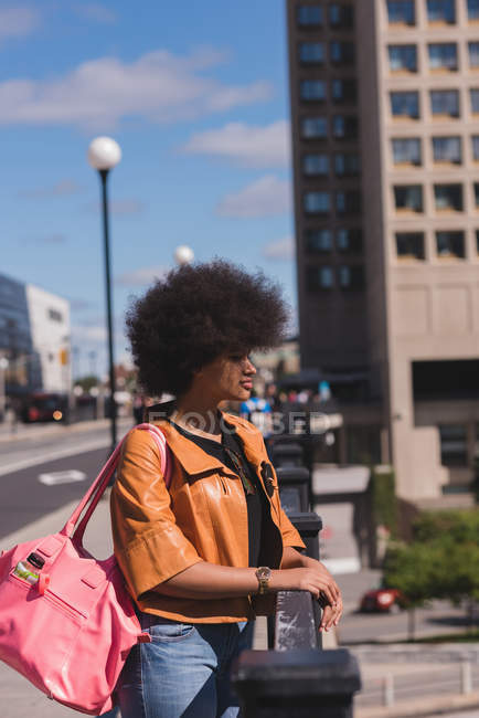 Вдумлива жінка стоїть на перилах у місті — стокове фото