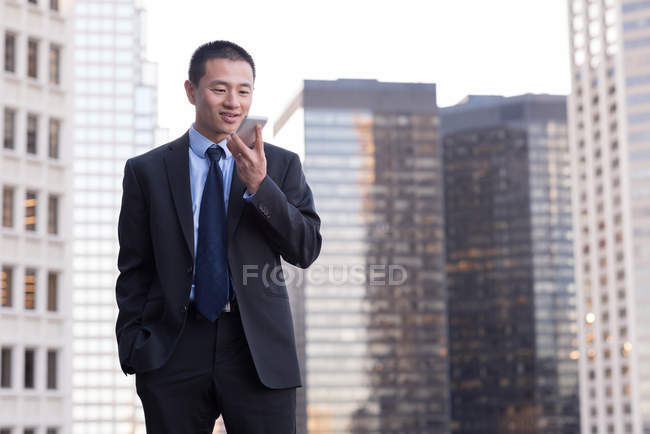 Empresario hablando por teléfono móvil en balcón en el hotel - foto de stock