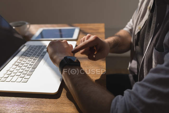 Immagine ritagliata di dirigente maschile utilizzando smartwatch in ufficio — Foto stock