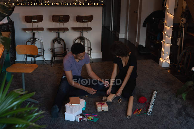 Paar verpackt Geschenkbox im heimischen Wohnzimmer — Stockfoto