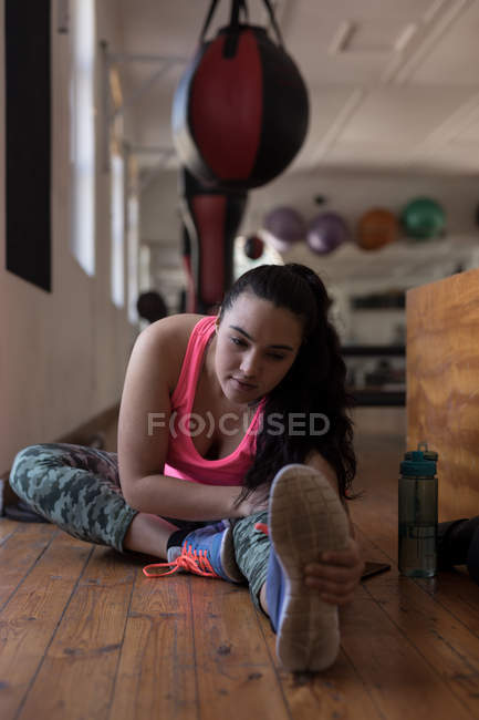 Beautiful female boxer stretching in fitness studio — Stock Photo