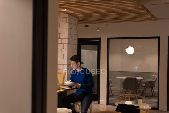 Ejecutiva masculina usando tableta digital en cafetería de oficina - foto de stock