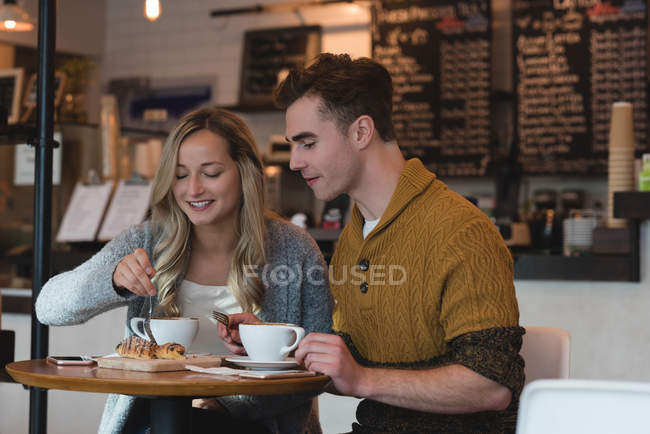 Casal jovem ter comida doce no café — Fotografia de Stock