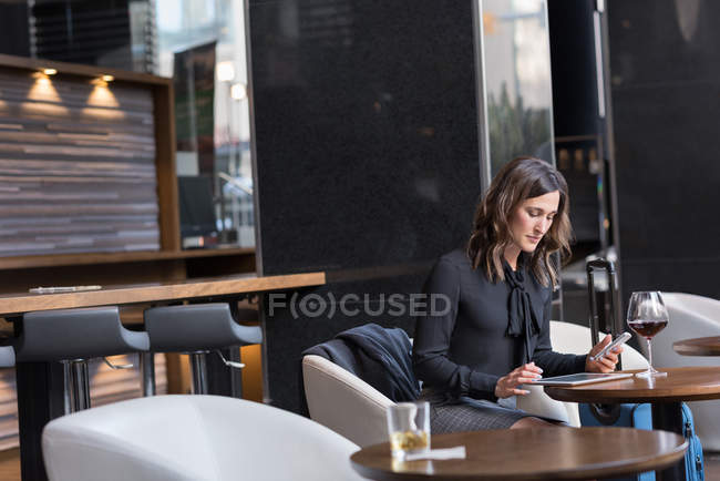 Mulher de negócios usando tablet digital no sofá no hotel — Fotografia de Stock