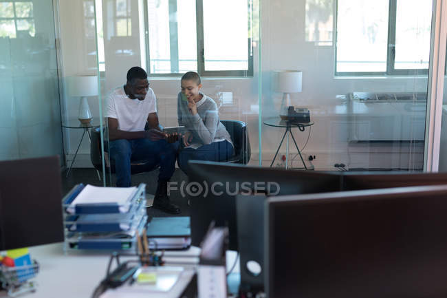 Керівники бізнесу обговорюють цифровий планшет в офісі — стокове фото