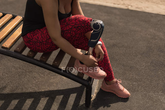 Низкая часть женщины-инвалида завязывающей шнурки — стоковое фото