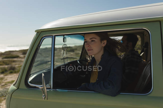 Woman looking through car window on roadtrip — Stock Photo