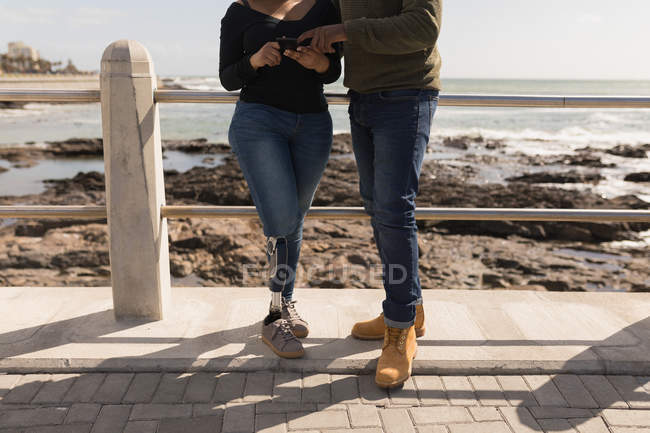 Paar diskutiert auf Promenade am Handy — Stockfoto