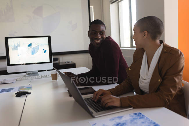 Executivo de negócios sorridente conversando uns com os outros no escritório — Fotografia de Stock