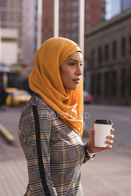 Femme hijab prenant un café dans la rue de la ville — Photo de stock