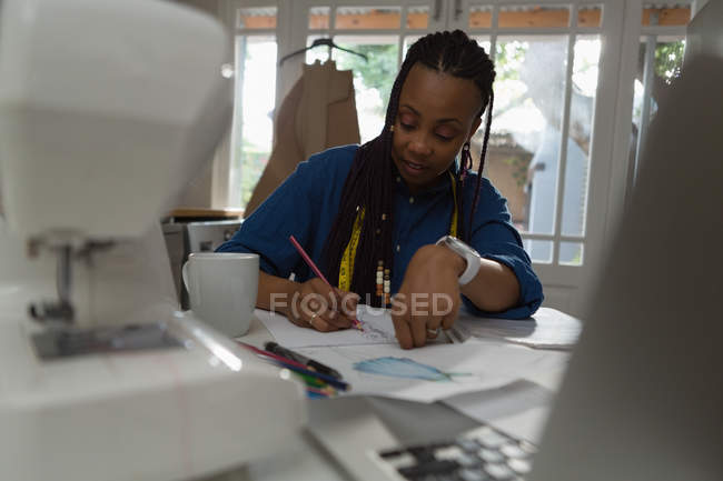Woman writing about her work in paper at home — Stock Photo