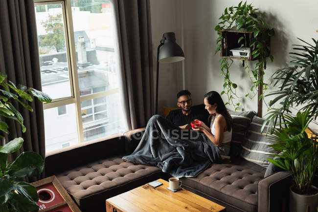 Пара с супом на диване в гостиной дома — стоковое фото