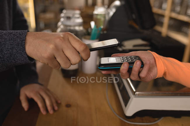 Close-up of customer making payment at counter in supermarket — Stock Photo