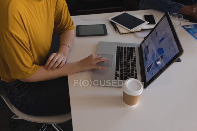 Mid section of female executive using laptop in conference room — Stock Photo