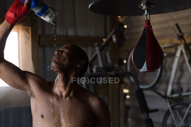 Male boxer pouring water on his face in boxing club — Stock Photo
