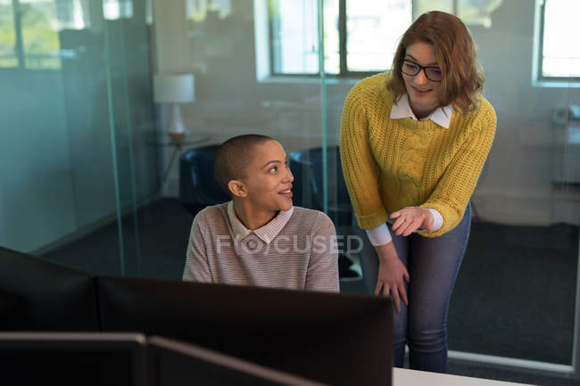 Женщины-руководители бизнеса разговаривают друг с другом в офисе — стоковое фото