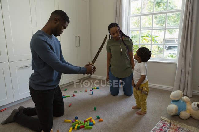 Famille jouant avec un fils dans un salon à la maison — Photo de stock