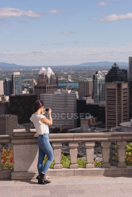 Rear view of woman clicking photo on mobile phone — Stock Photo