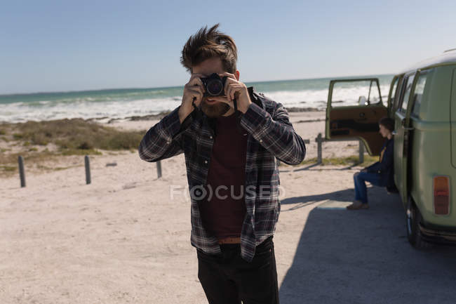 Homme prenant des photos près de la plage en road trip — Photo de stock