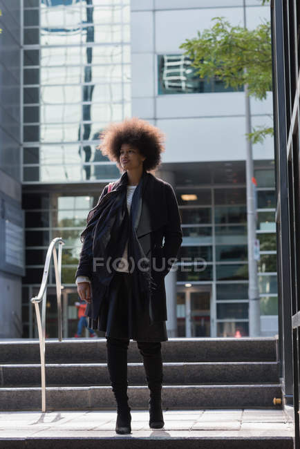 Mujer pensativa caminando en la ciudad - foto de stock