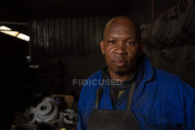 Retrato del trabajador masculino de pie en la fundición - foto de stock