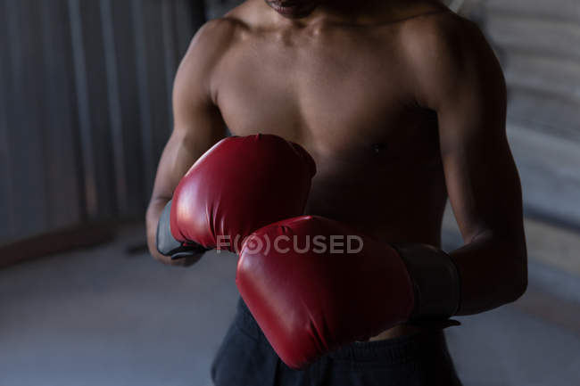 Mid section of male boxer practicing boxing in fitness studio — Stock Photo