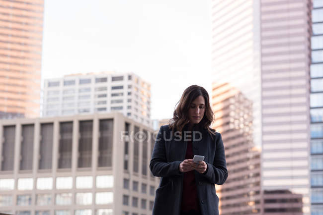 Businesswoman using mobile phone in balcony at home — Stock Photo