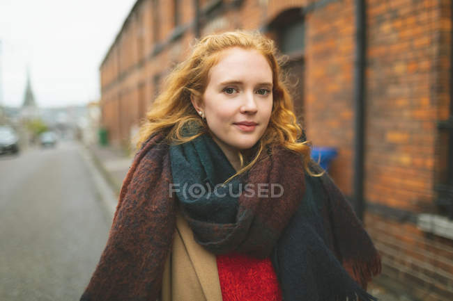 Rossa donna a piedi sulla strada della città — Foto stock