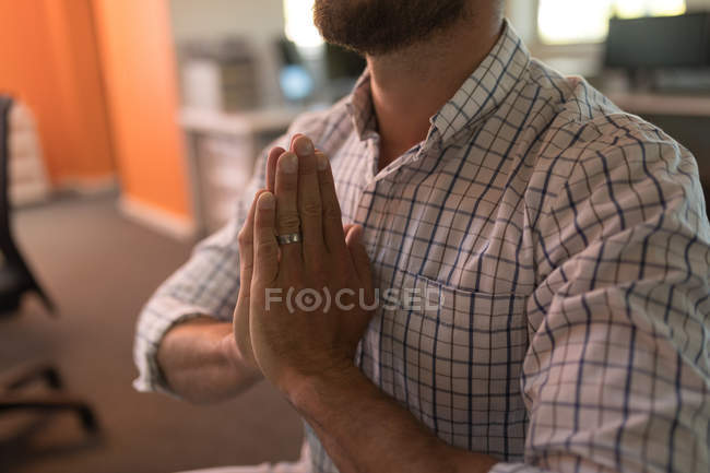 Mid section of business executive doing yoga in office — Stock Photo